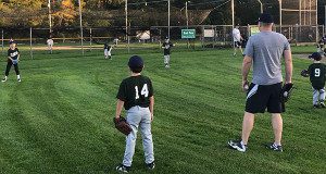 First and second graders warm up before their fall baseball game.