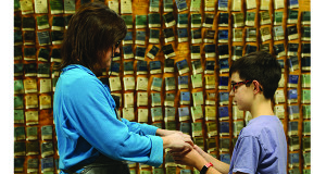 Donegan helps a student pick out the color he’ll paint his pot.