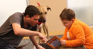 Owner Adam Cutter helps sound out some words while Tucker takes a closer look.