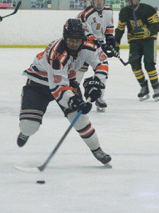 Junior defenseman Liam Fisher (15) moves the puck into the offensive end. Photos by Michael Flanagan