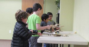 A group of boy try their grabbers out. 