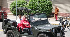 Veterans ride aboard the “Mike-1” Jeep during the parade to Needham Town Common.
